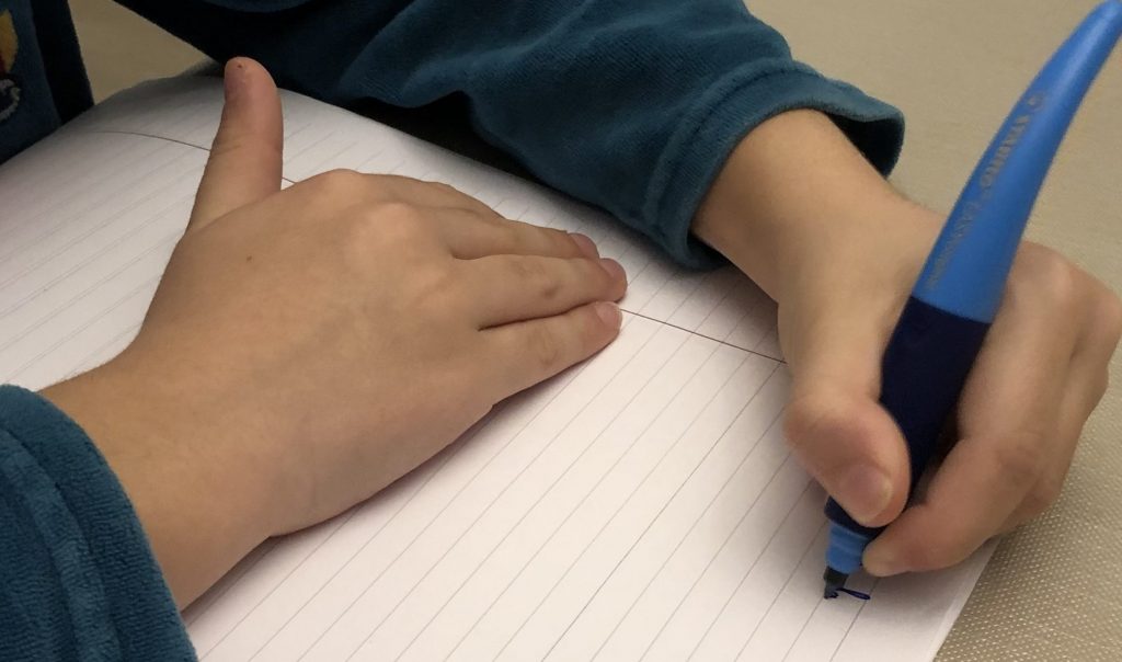 Enfant qui écrit sur une feuille